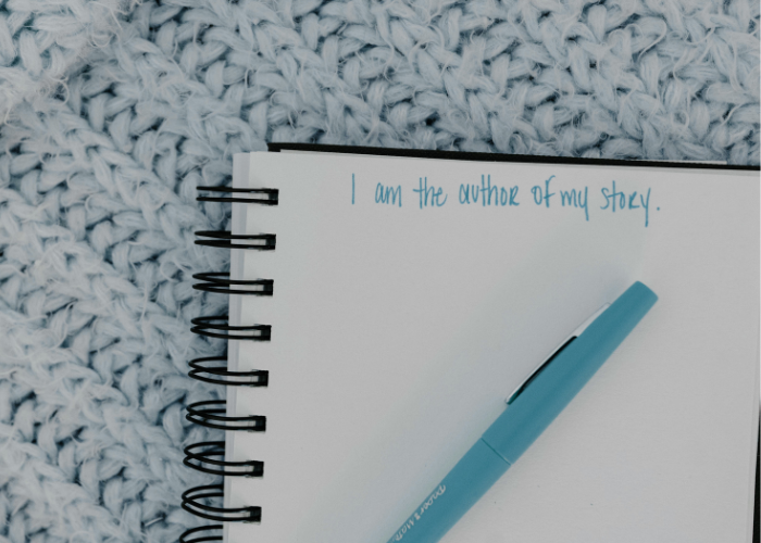 Notebook with a pen on top opened to a page with the words "I am the author of my story" written at the top.